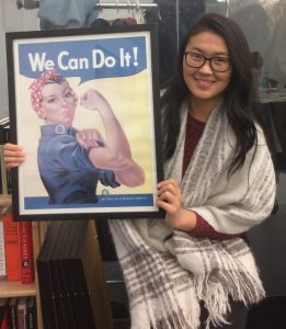 Meerim holding a "We Can Do It" Rosie the Riveter sign.