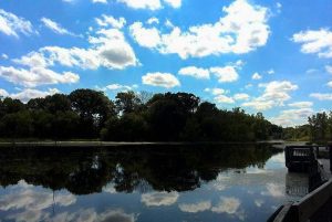 Clouds in the bright blue sky are reflected on the lake