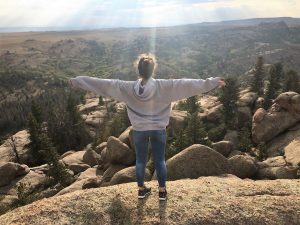 Kseniia put her arms out to welcome the sun from atop the rocky Vedauwoo