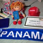 Lourdes' UGRAD Post on her bed with her Panama scarf, hat, schoolbag, doll, and passport