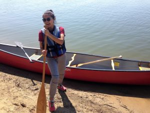 Migma poses with the paddle next to a canoe