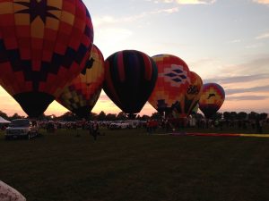 Hot air balloons lined up against the sunset