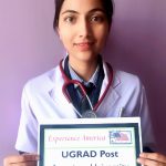 Purnima, wearing scrubs, holds her UGRAD Post