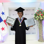 Karan in his graduation gown wearing medals and holding his diploma and UGRAD Post