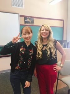 Ni Mo is posing with her English Composition professor, Kelly Lucero in a classroom. 
