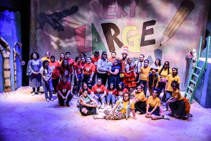 The cast of Seussical pose on stage for a group photo