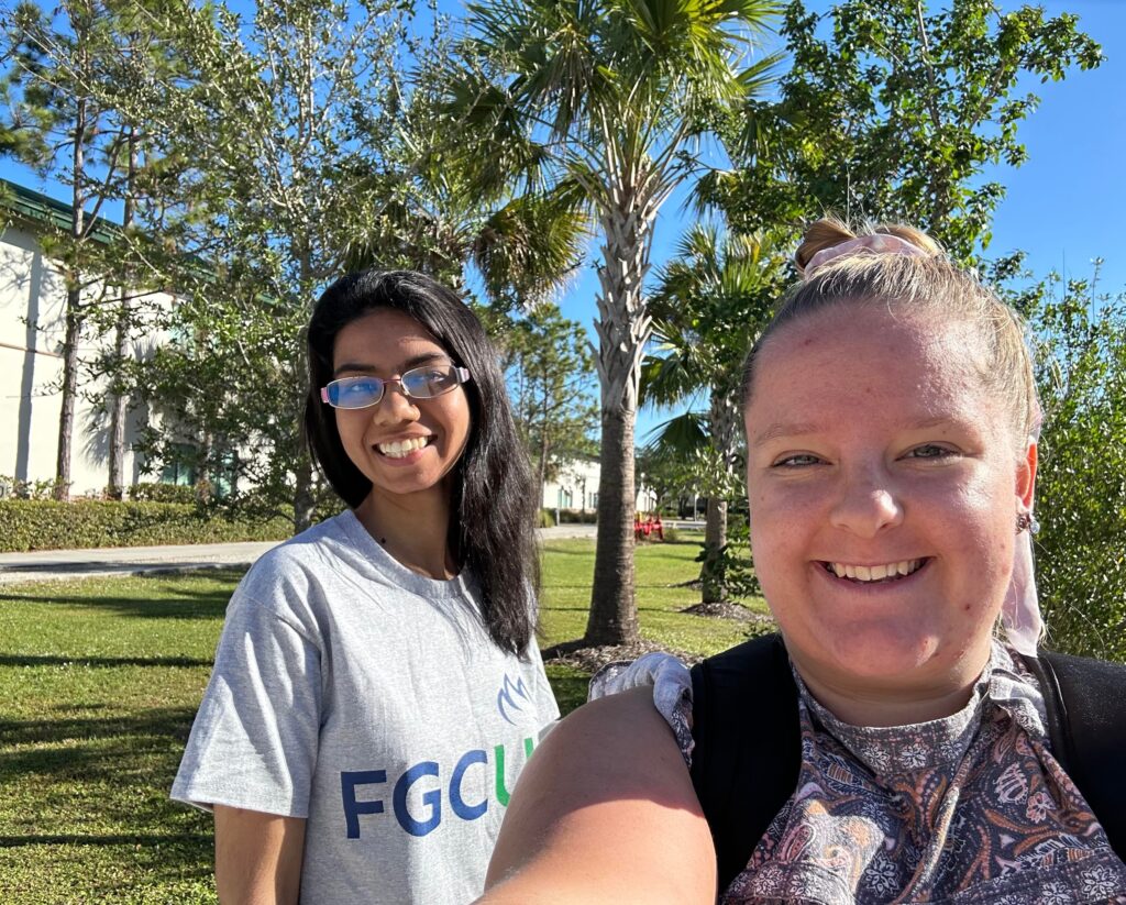 Hervinder and her friend Dani smiling on a sunny day walking through FGCU's campus